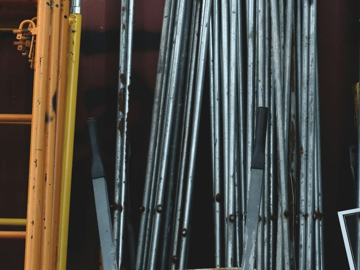 Galvanised scaffold tubes and fittings stored upright in a supply yard
