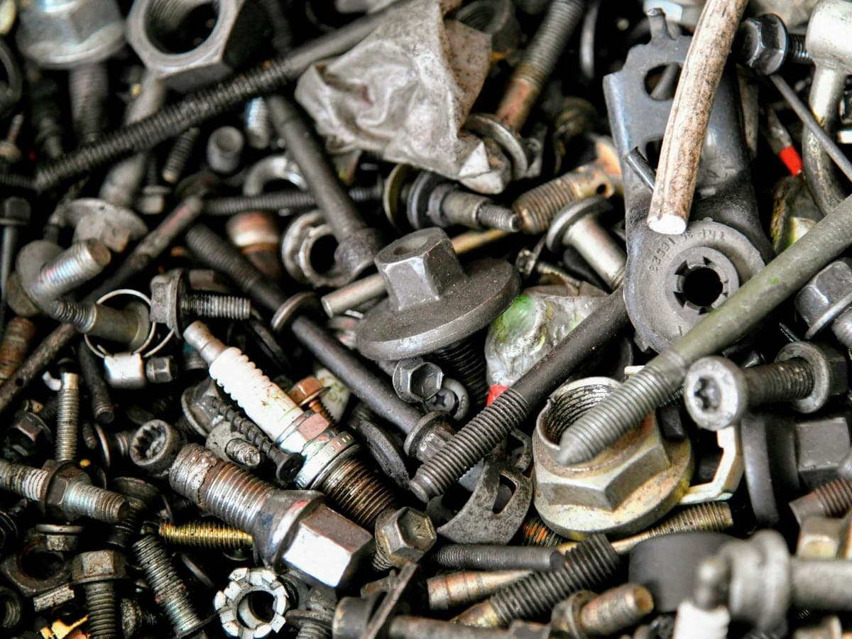 Close-up of assorted steel nuts, bolts and fasteners in a supply bin